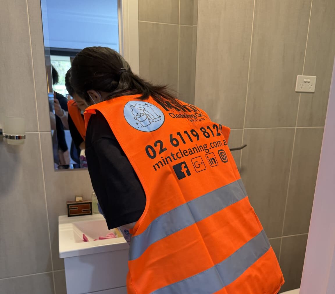 Cleaner wiping a bathroom vanity during end-of-lease cleaning in Canberra