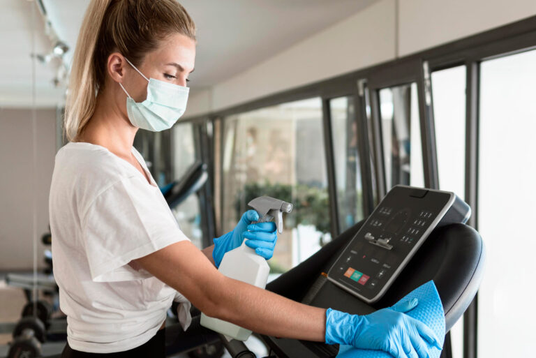 Professional cleaner sanitising equipment in a commercial facility