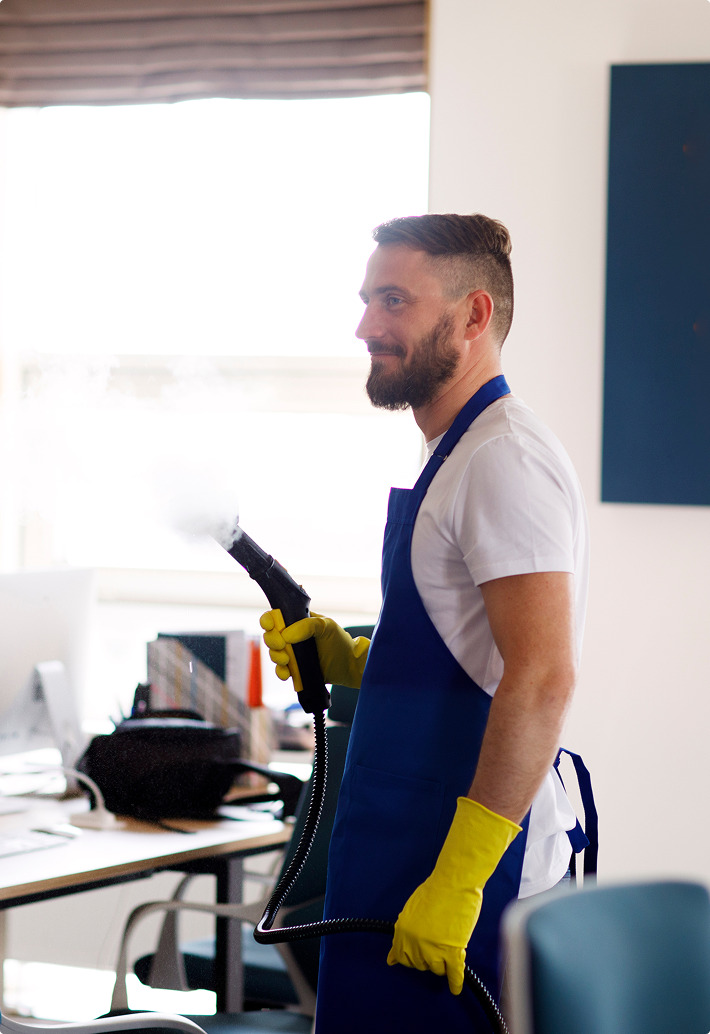 Cleaner wiping and sanitising a commercial surface in Canberra