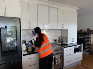 Professional cleaner wiping a workplace kitchen in Canberra