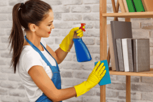 A woman holding cleaning the shelf