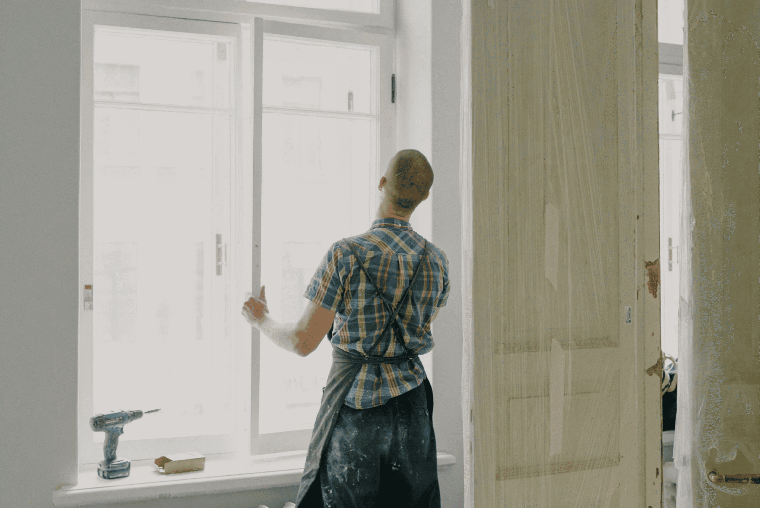 A man repairing the window and door